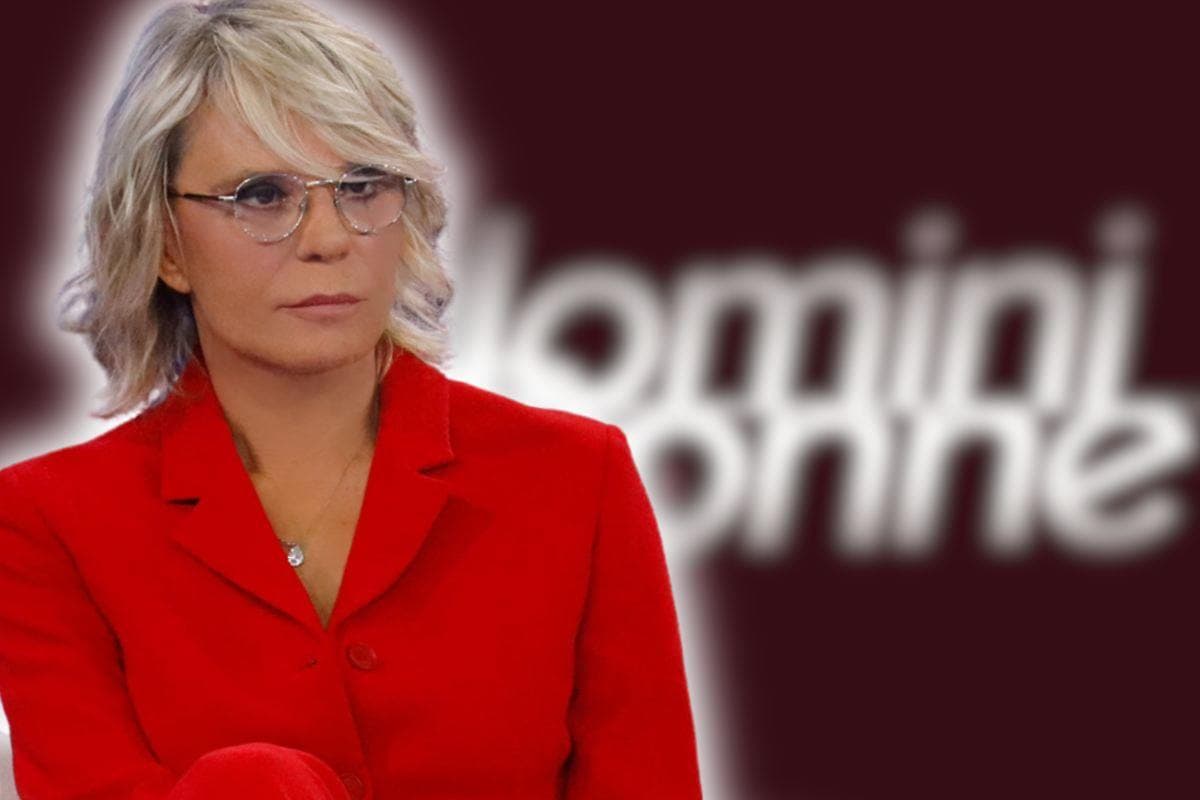 maria de filippi con il logo di uomini e donne alle spalle